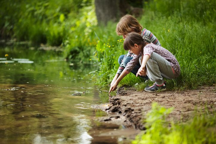 Nens gaudin mirant en un riu